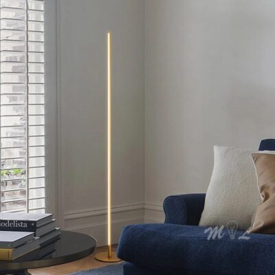 Gold slim LED floor lamp in a living room corner next to a blue sofa